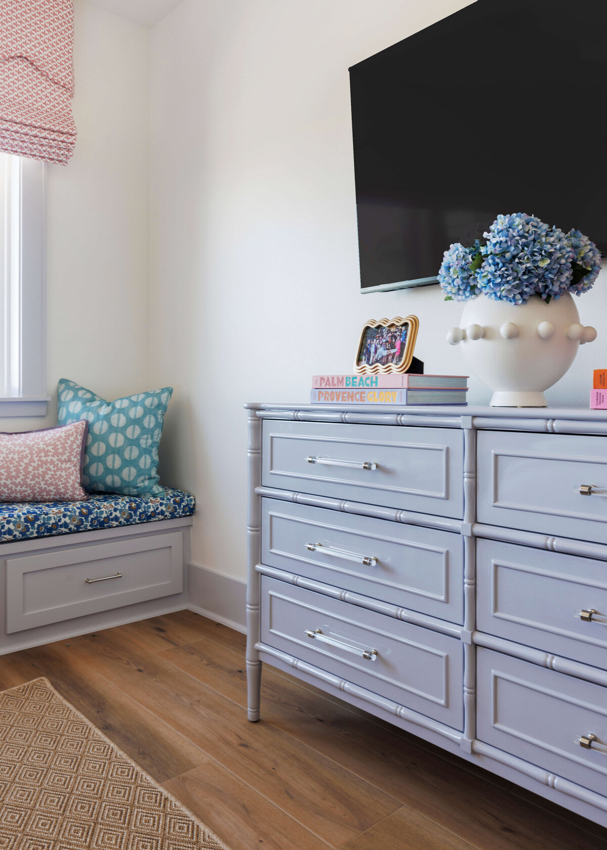 oyster creek studios lighthouse on the lake slate blue dresser with tv and books next to window bench with storage in bedroom