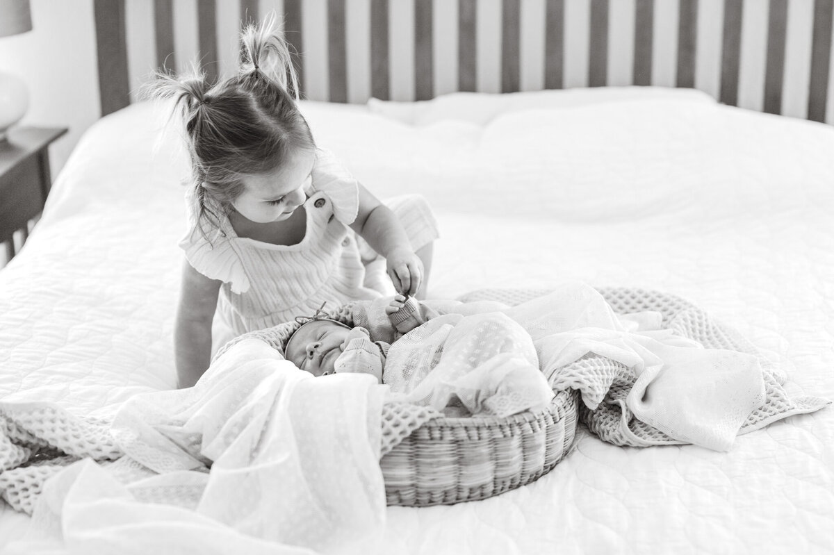 Black and white image of sisters on mom and dad's bed.