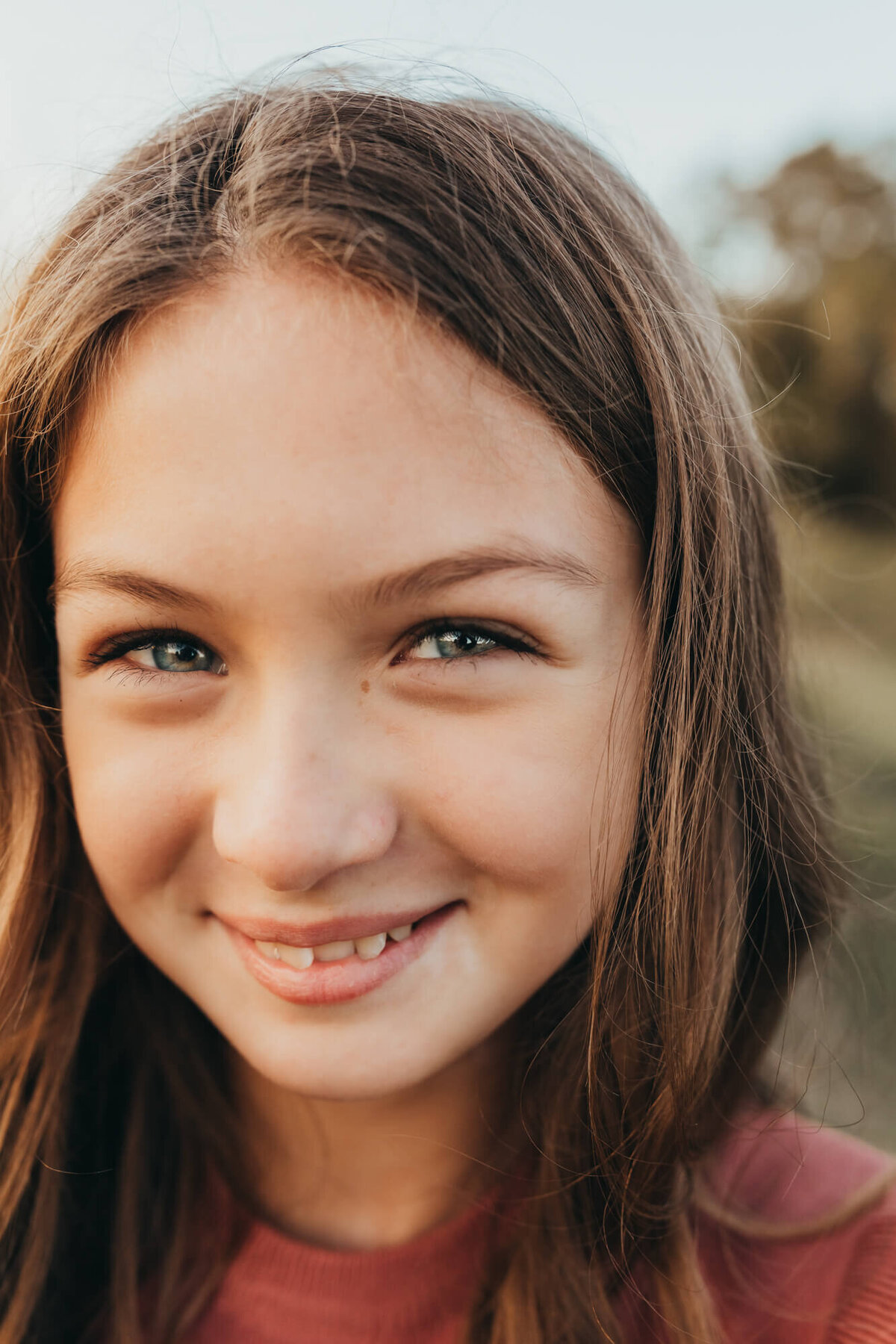 detail shot of preteen girl smiling at the camera.