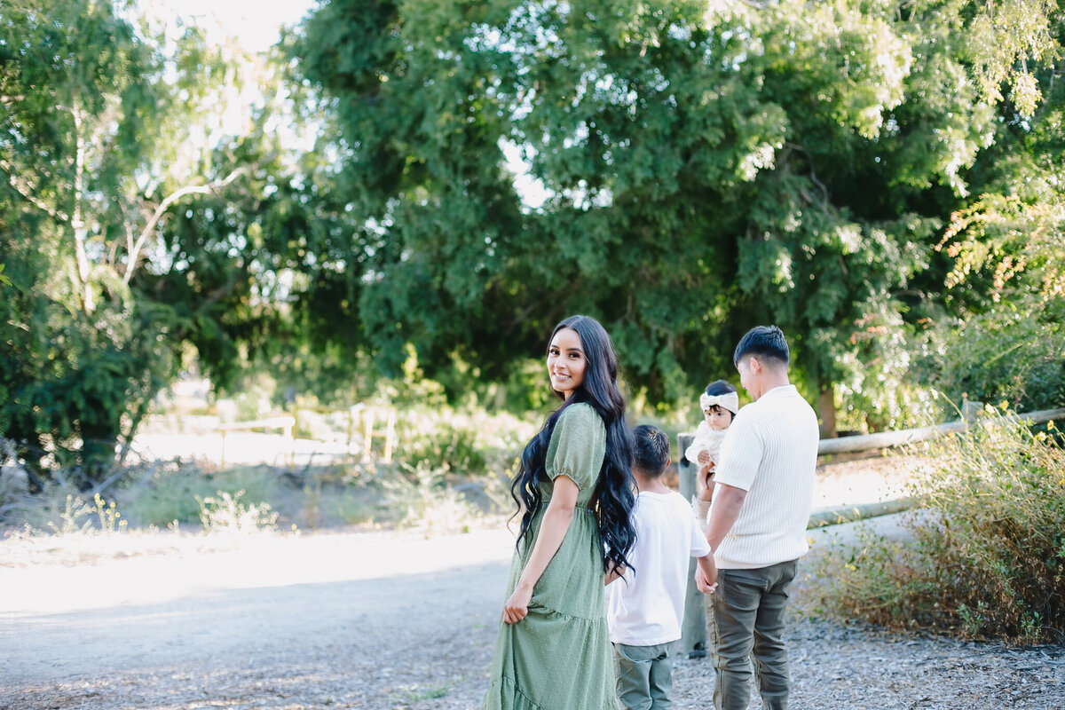 Mother walking in field with her family