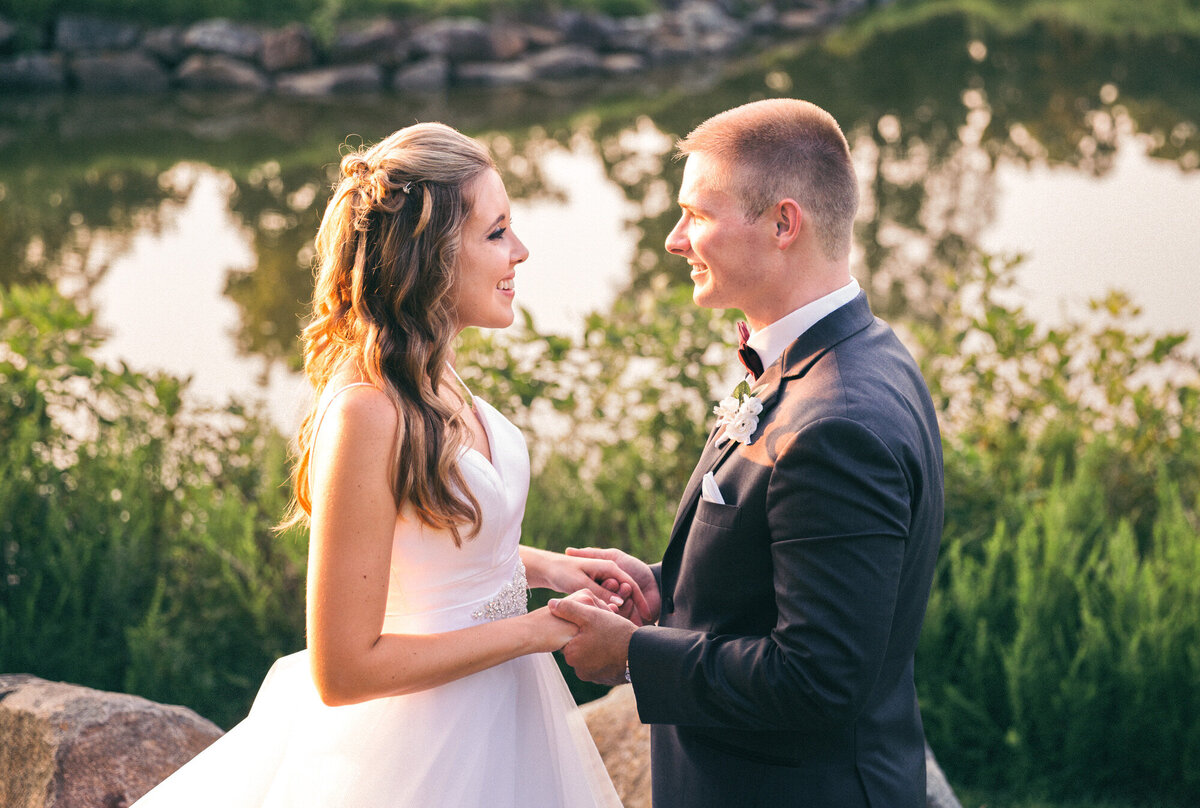 Bride and groom holding hands looking at each other after getting married