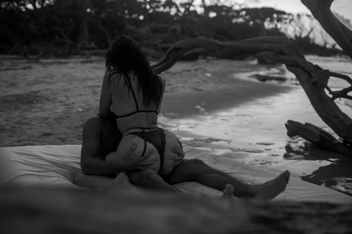 couple in sexy lingerie at the beach on an air mattress kissing each other
