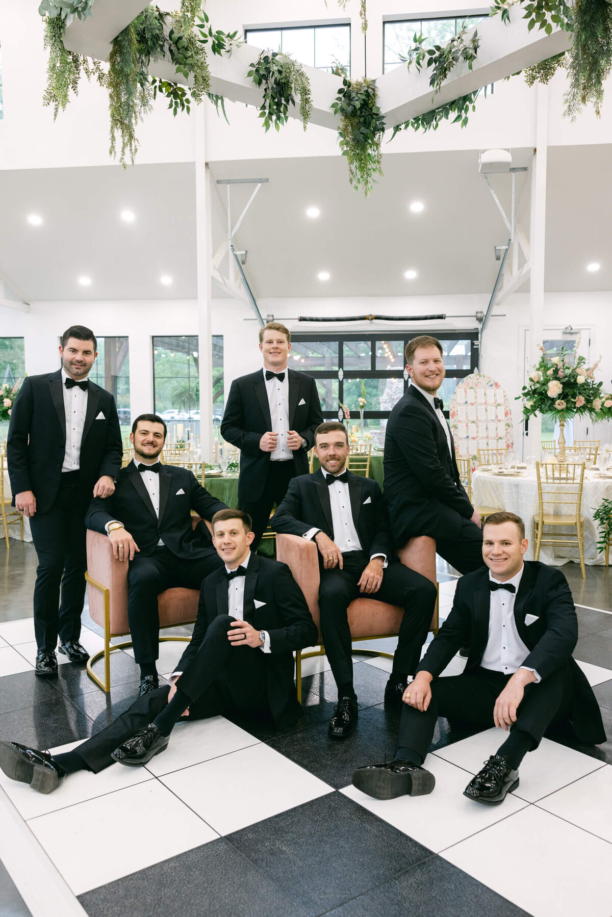 A wedding day photo of the groom with his groomsmen posing for a photo