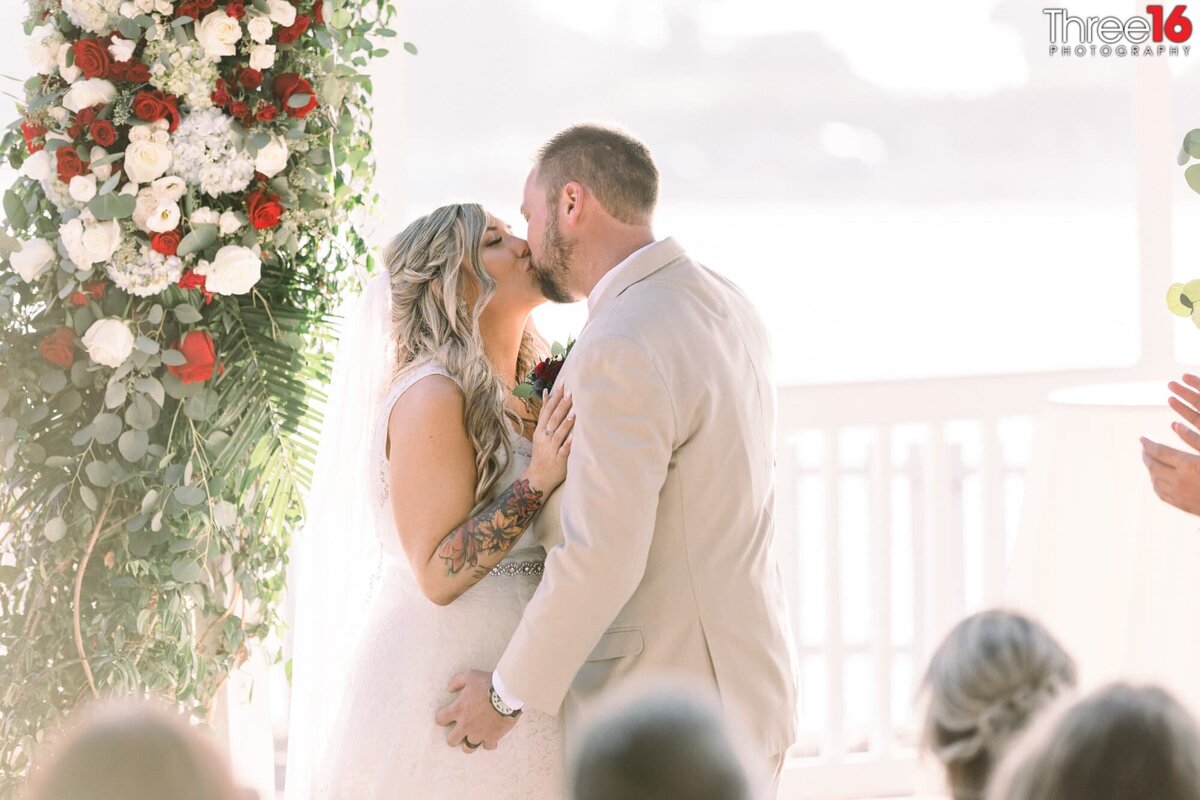 Bride and Groom share their first kiss as a married couple at the altar