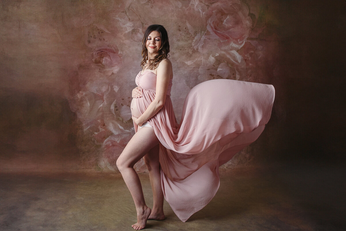 Pregnant woman in a pink flowing maternity gown
