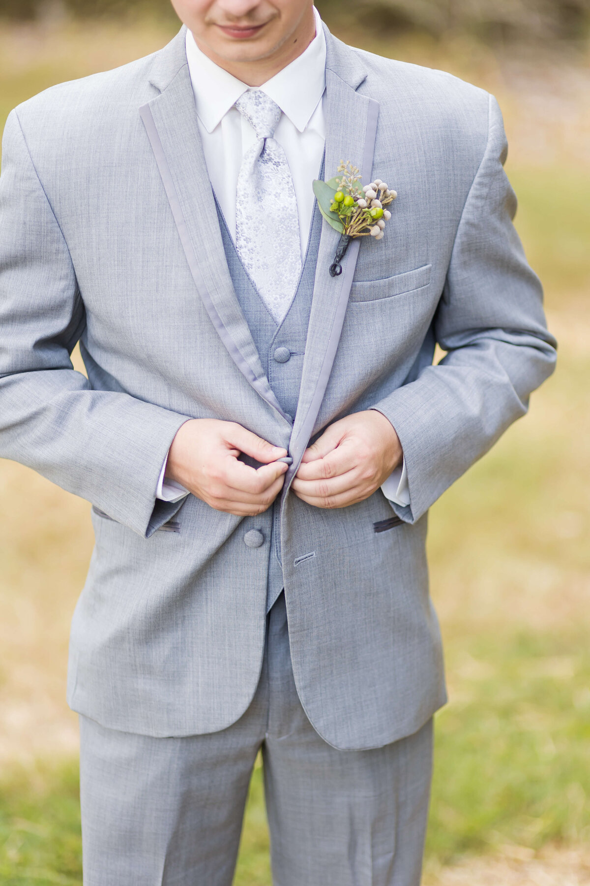 Groom buttoning up suit at wedding at Mahr Park, Tennessee