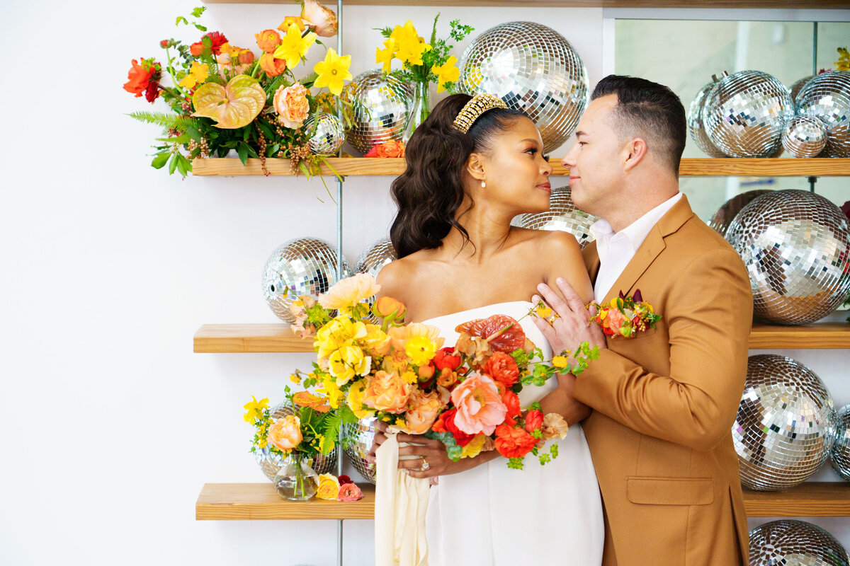 Bride’s bouquet with bright yellow and orange flowers and greenery, styled for a modern wedding