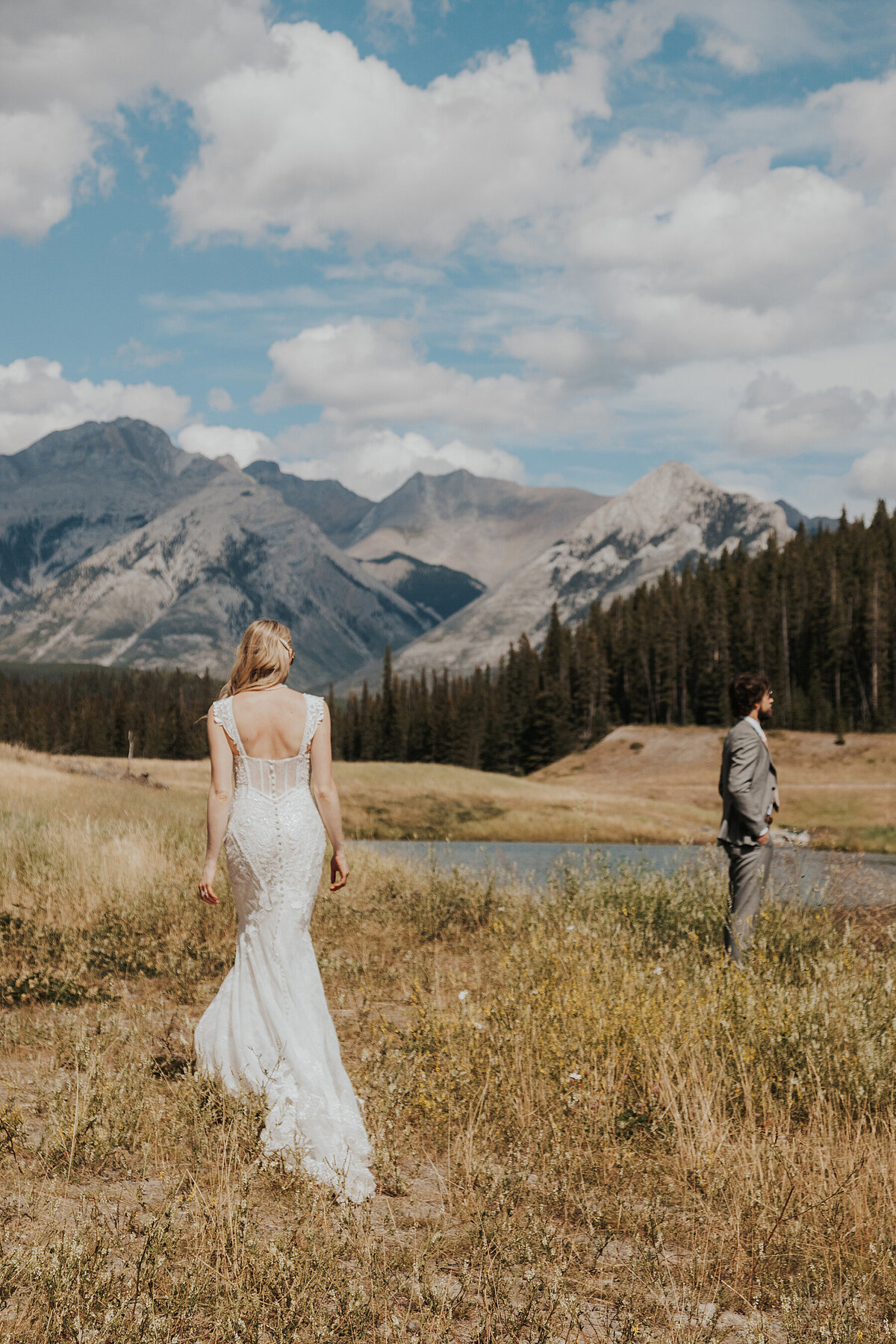 A bride walks up to her groom for a first look in Banff National Park