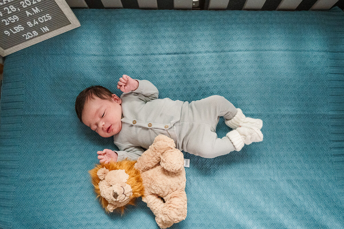 newborn sleeping on blue blanket in crib during home session harrisburgharrisburg-pa