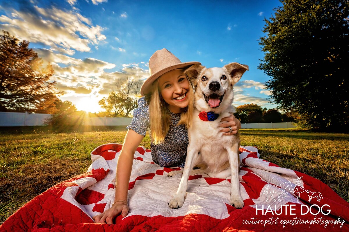 Wide-angle portrait of a woman laying on a blanket outdoors with her loyal senior Collie dog.