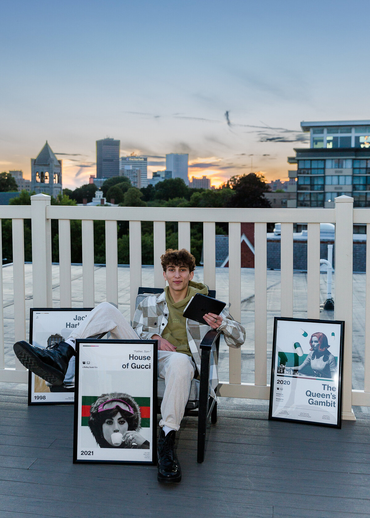 Unique senior photo taken on a rooftop in Rochester, NY. Boy with his modern artwork posters