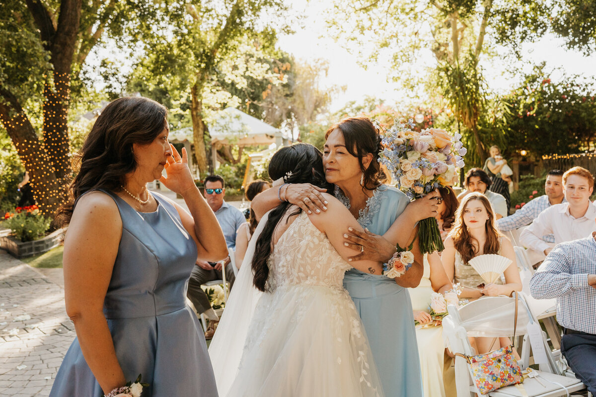 A person hugging someone in a wedding dress during their wedding ceremony 