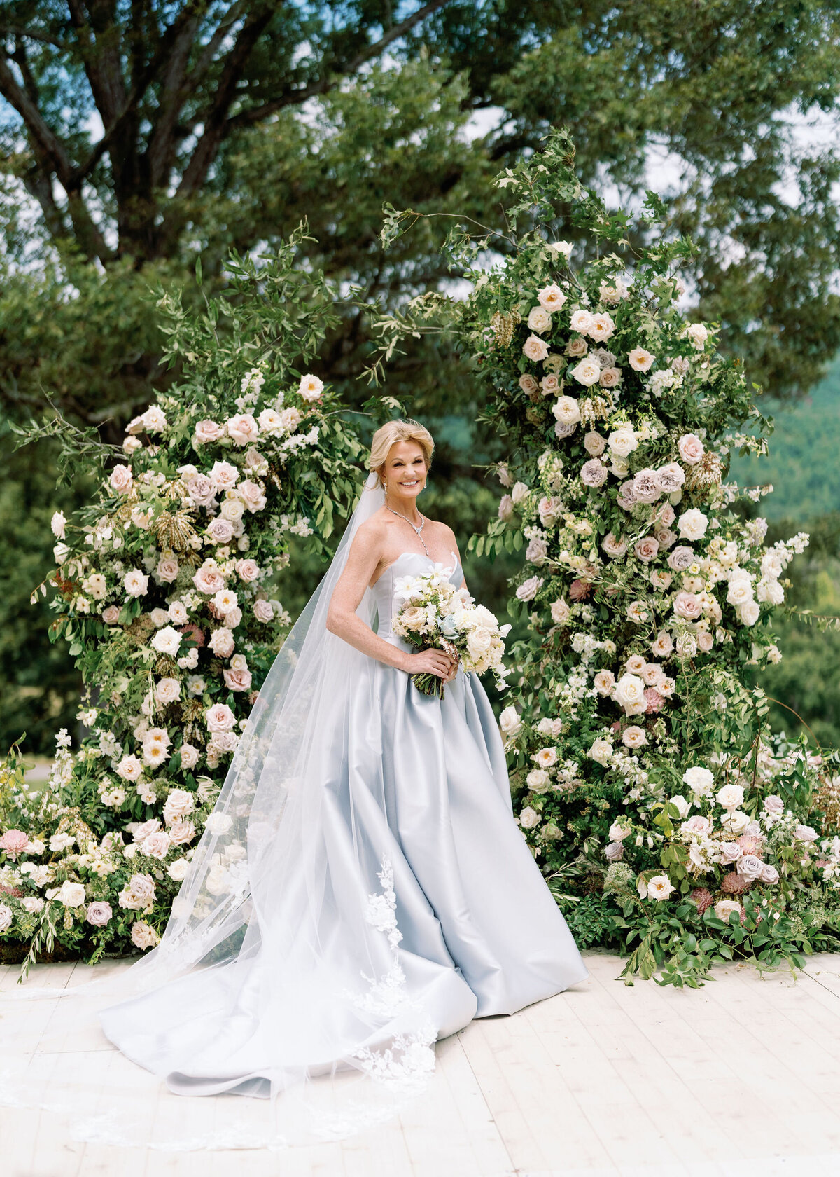 Epic ceremony backdrop for fall wedding at Blackberry Farms. Lush broken arch floral design for wedding ceremony backdrop. Garden inspired growing floral in colors of cream, white, blush, and green. Full coverage floral aisle for wedding ceremony. Floral meadows with petal heavy roses. Floral heavy flora design with elegant and whimsical design. Destination wedding at Blackberry Farm. Design by Rosemary & Finch Floral Design in Nashville, TN. 