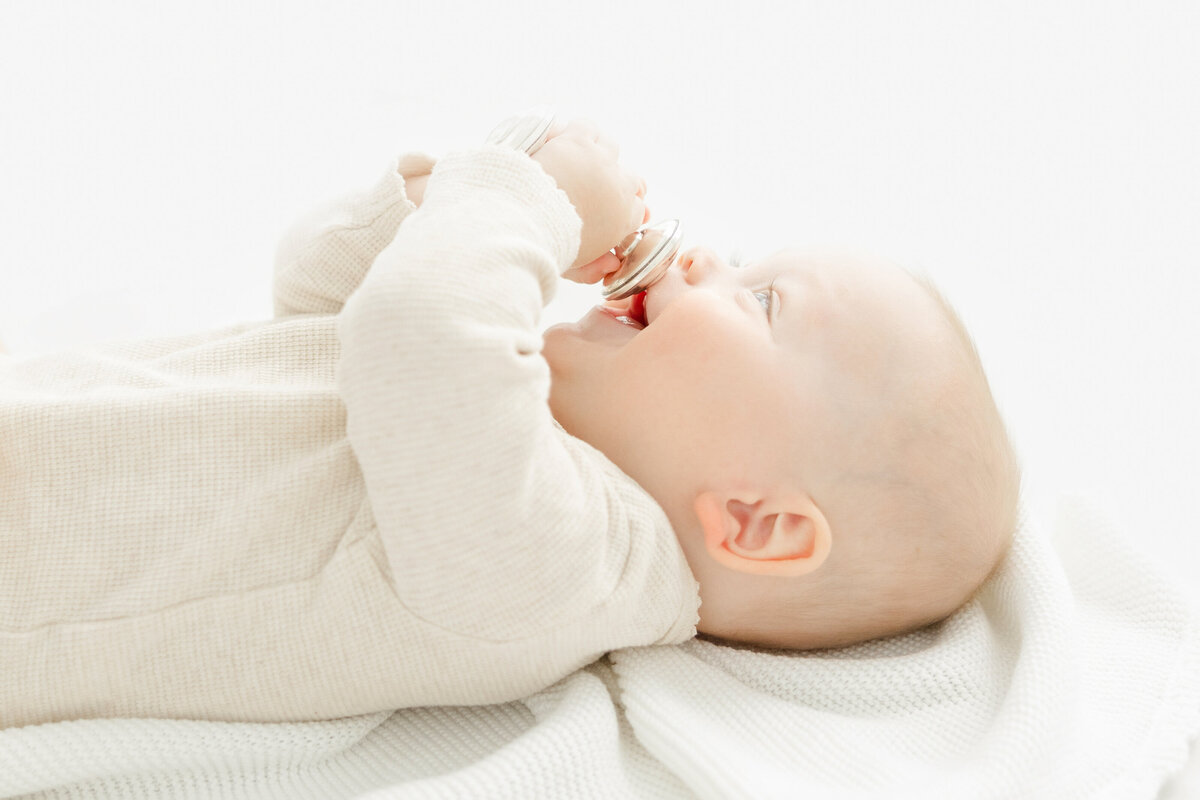 Side view of baby with a rattle by Northern Virginia Child Photographer