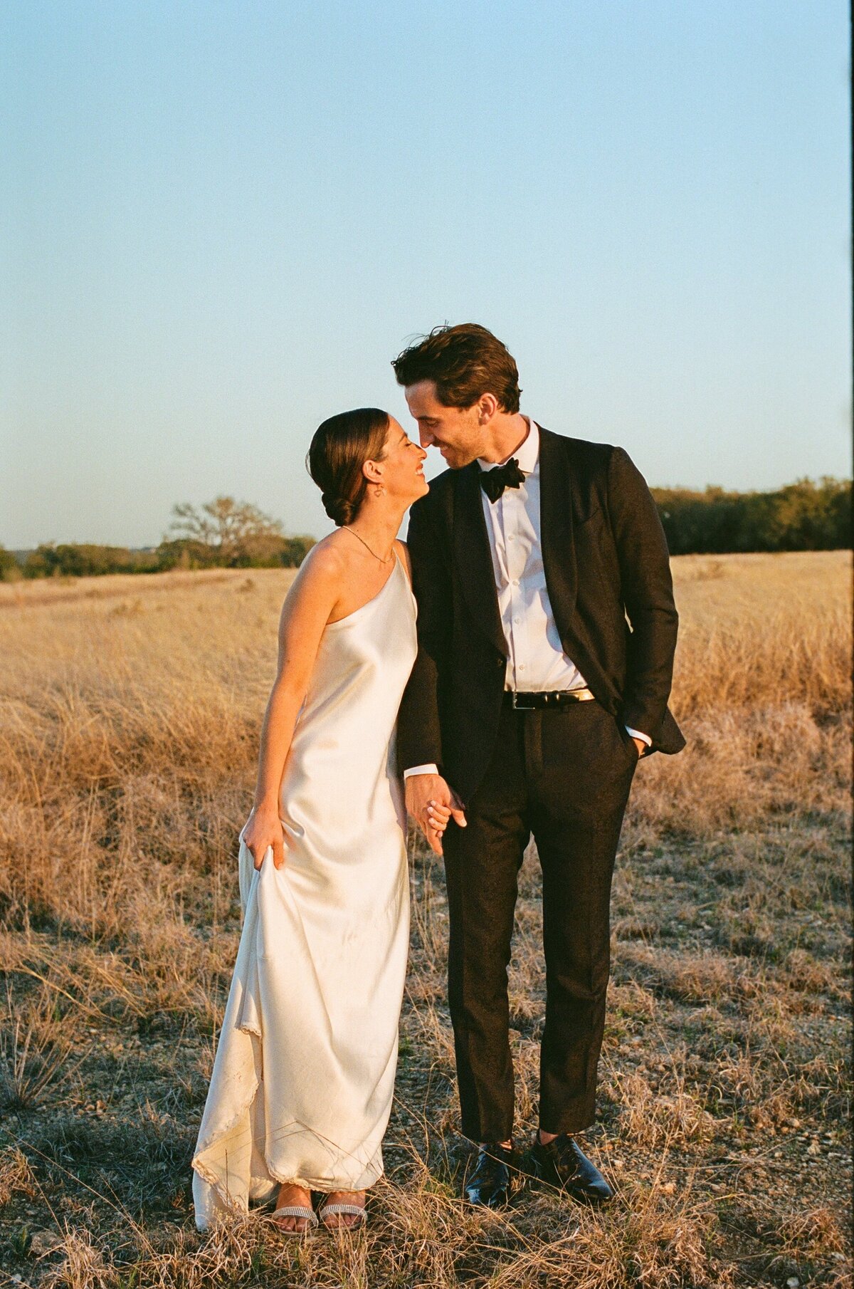 Bride and groom in a field at sunset for Austin wedding at Prospect House