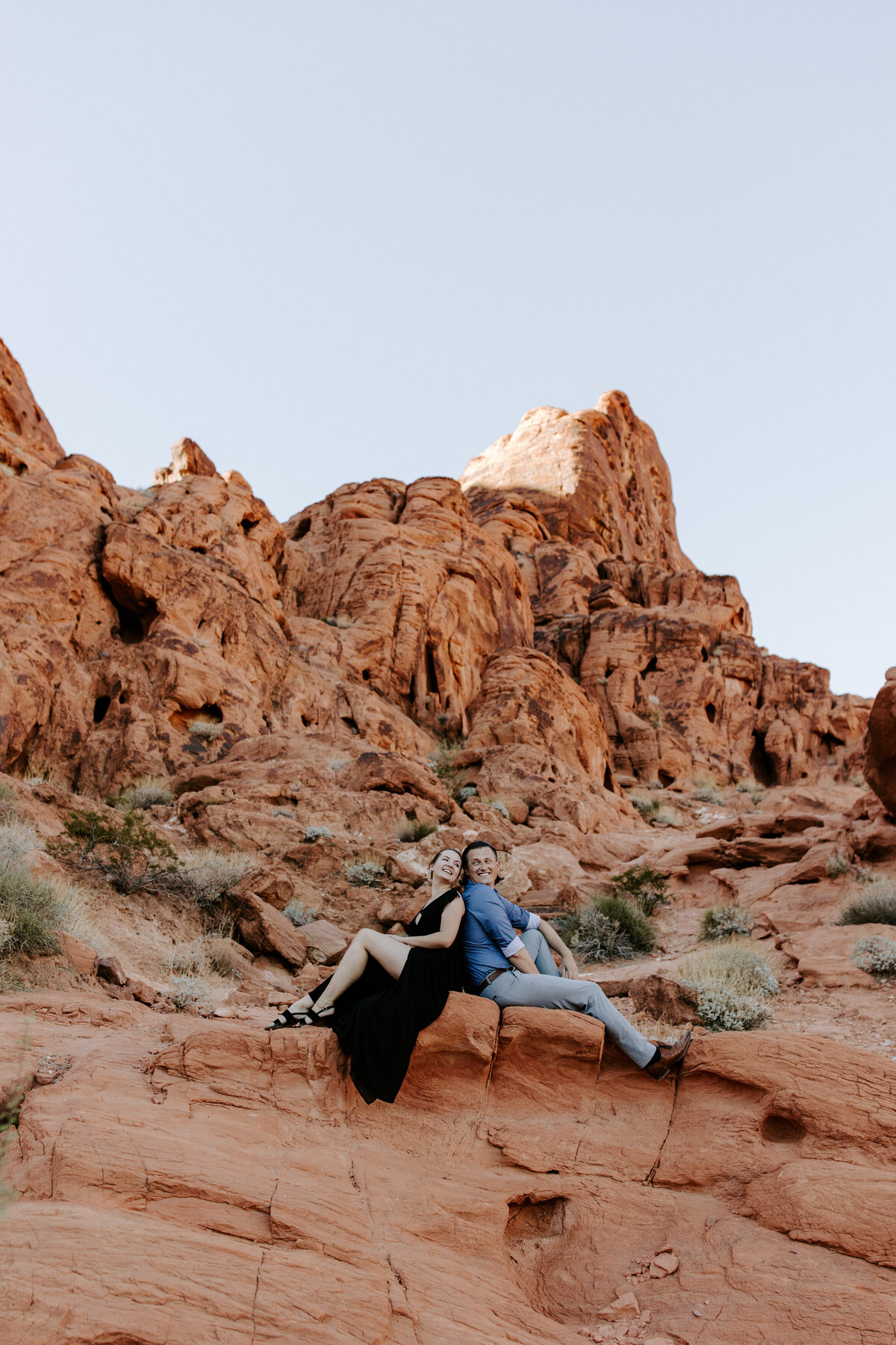 A couple sits back to back in Valley of Fire.