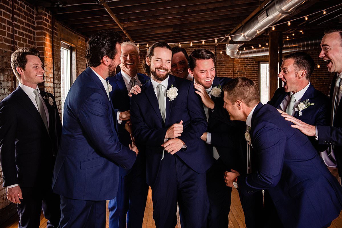 Groomsmen candidly laughing together with the groom