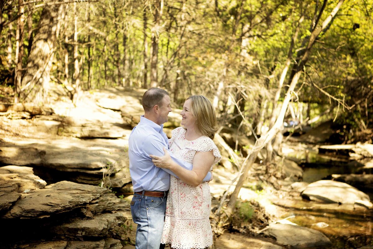 Parents standing in the creek in Flower Mound, sharing a sweet moment together as they pose for their photo session