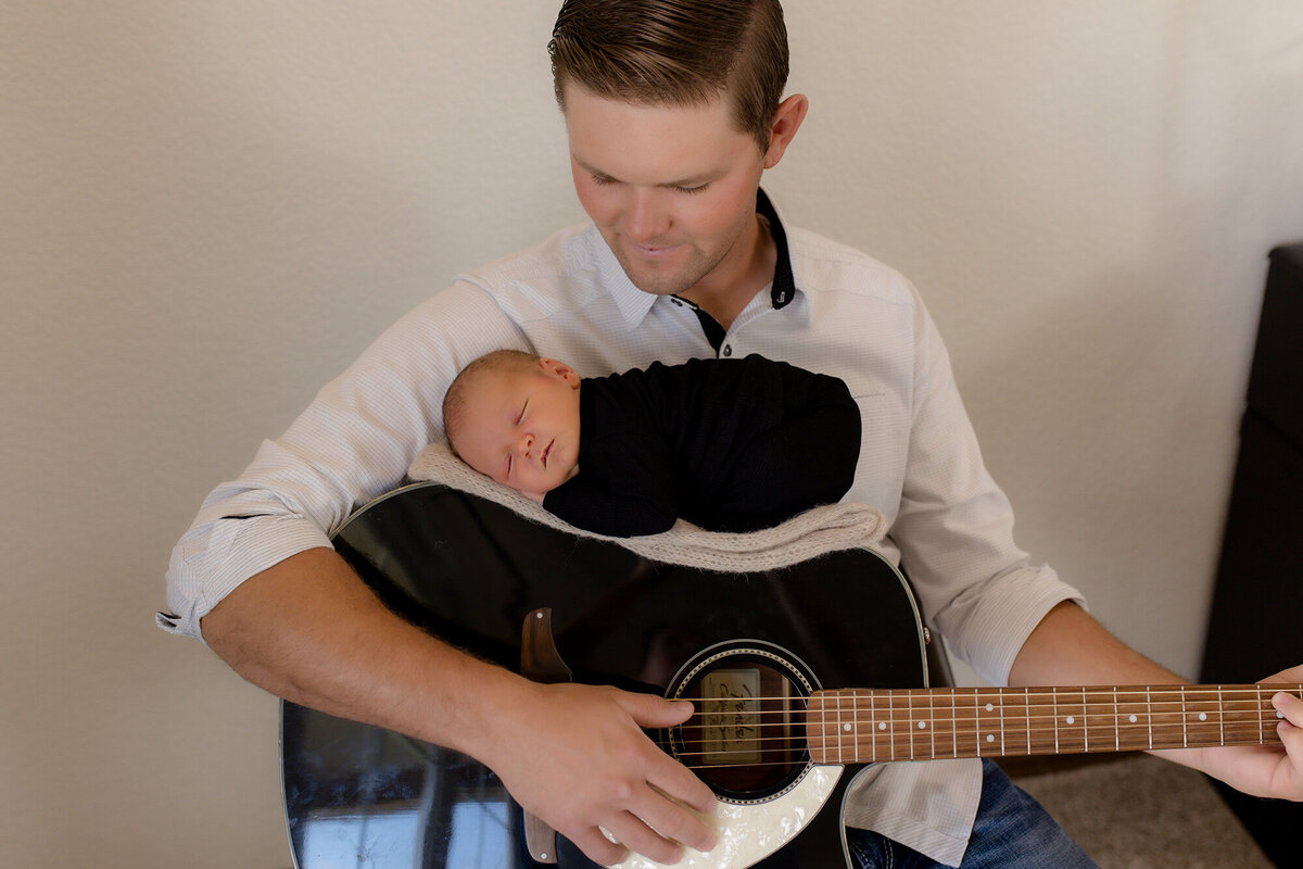 newborn photo of baby on guitar
