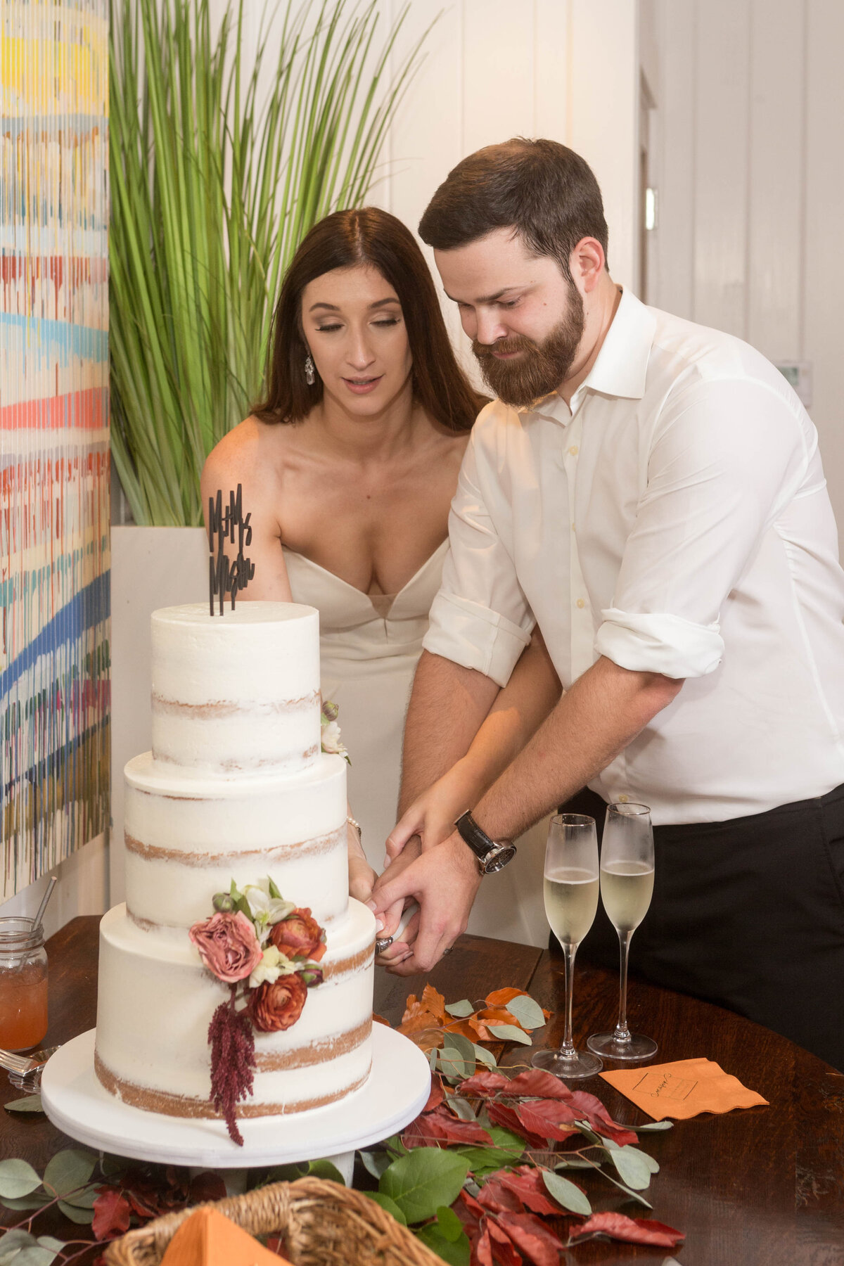 Maggie and Brandon cut the cake at their reception at Little Point Clear in Point Clear, Alabama.