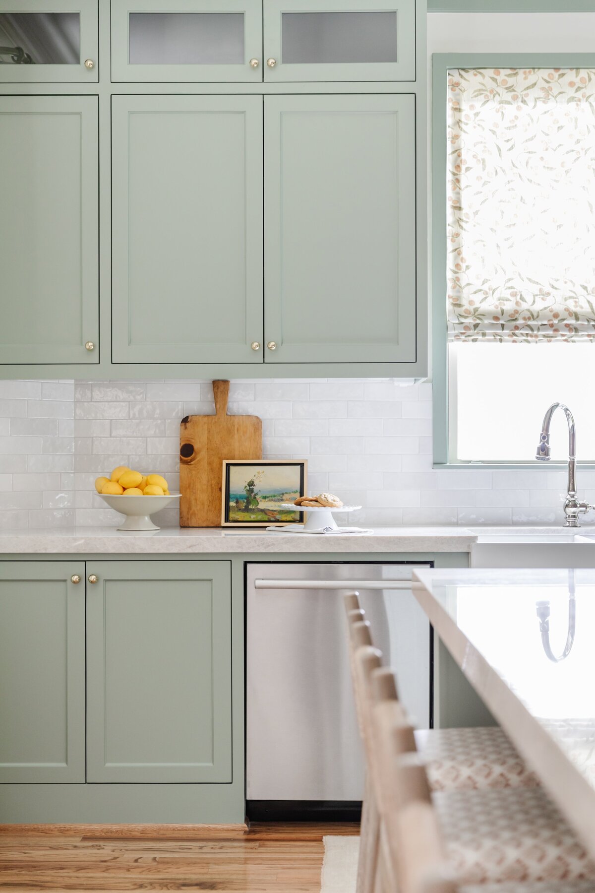 oyster creek studios oak forest remodel wooden cutting board and stainless steel dishwasher in light green kitchen