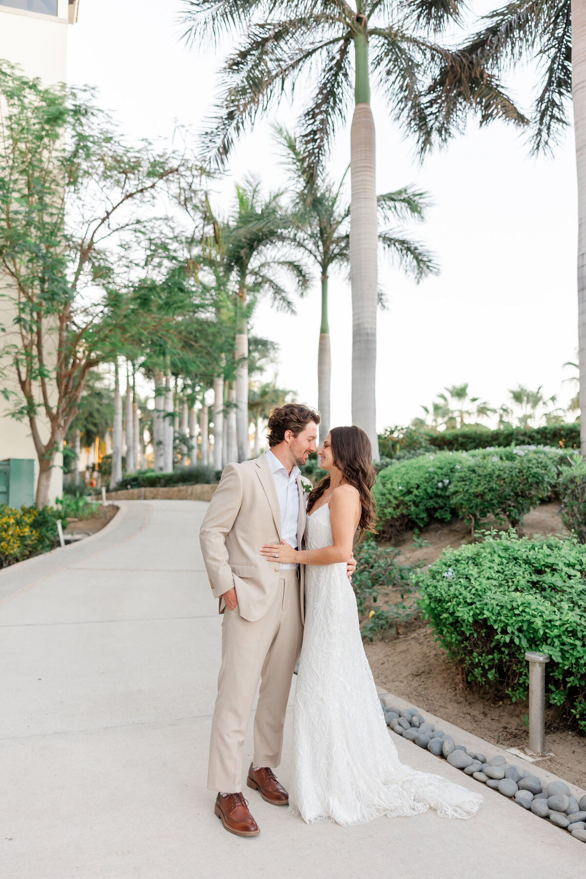 bride and groom framed on a path looking at each other by wedding photographers florida