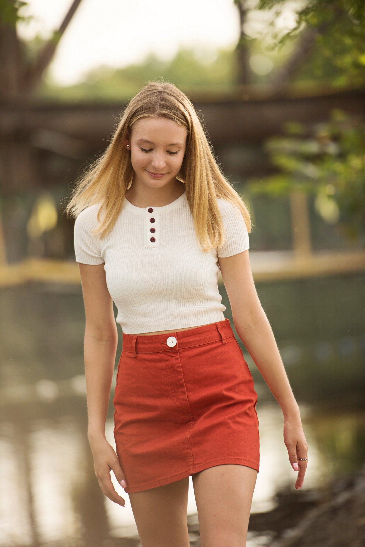 girl with orange skirt on side of river in Minneapolis