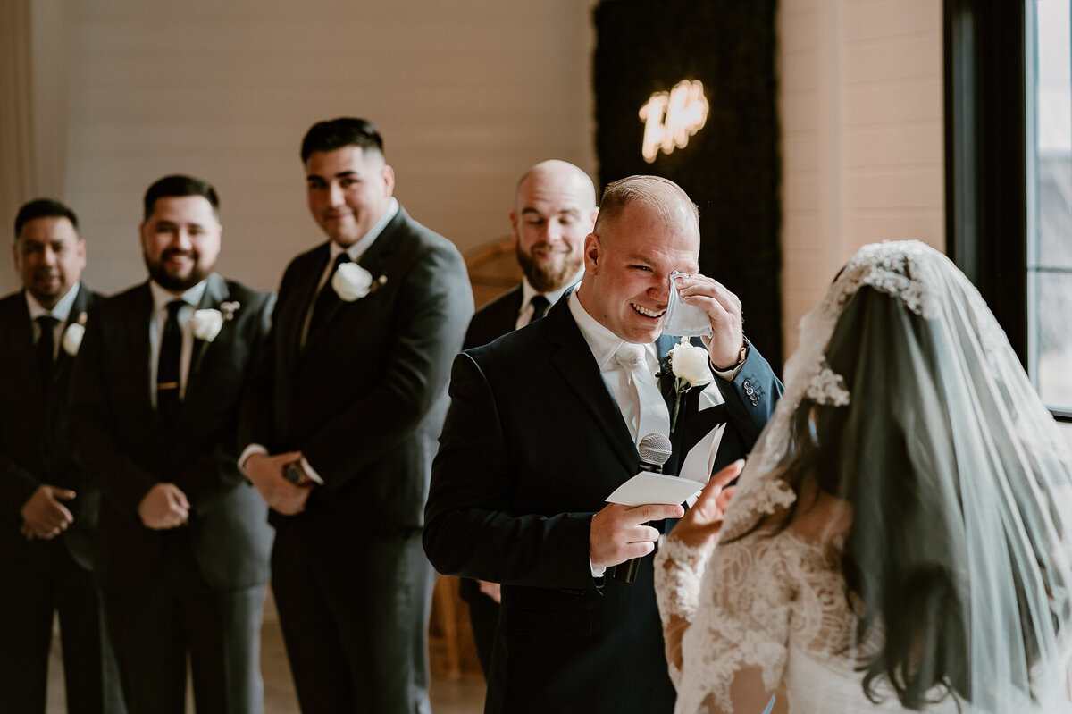 groom-crying-reading-vows-wedding-ceremony-ashton-hill-farm-cedar-rapids-iowa-storyteller-collective-photo-co