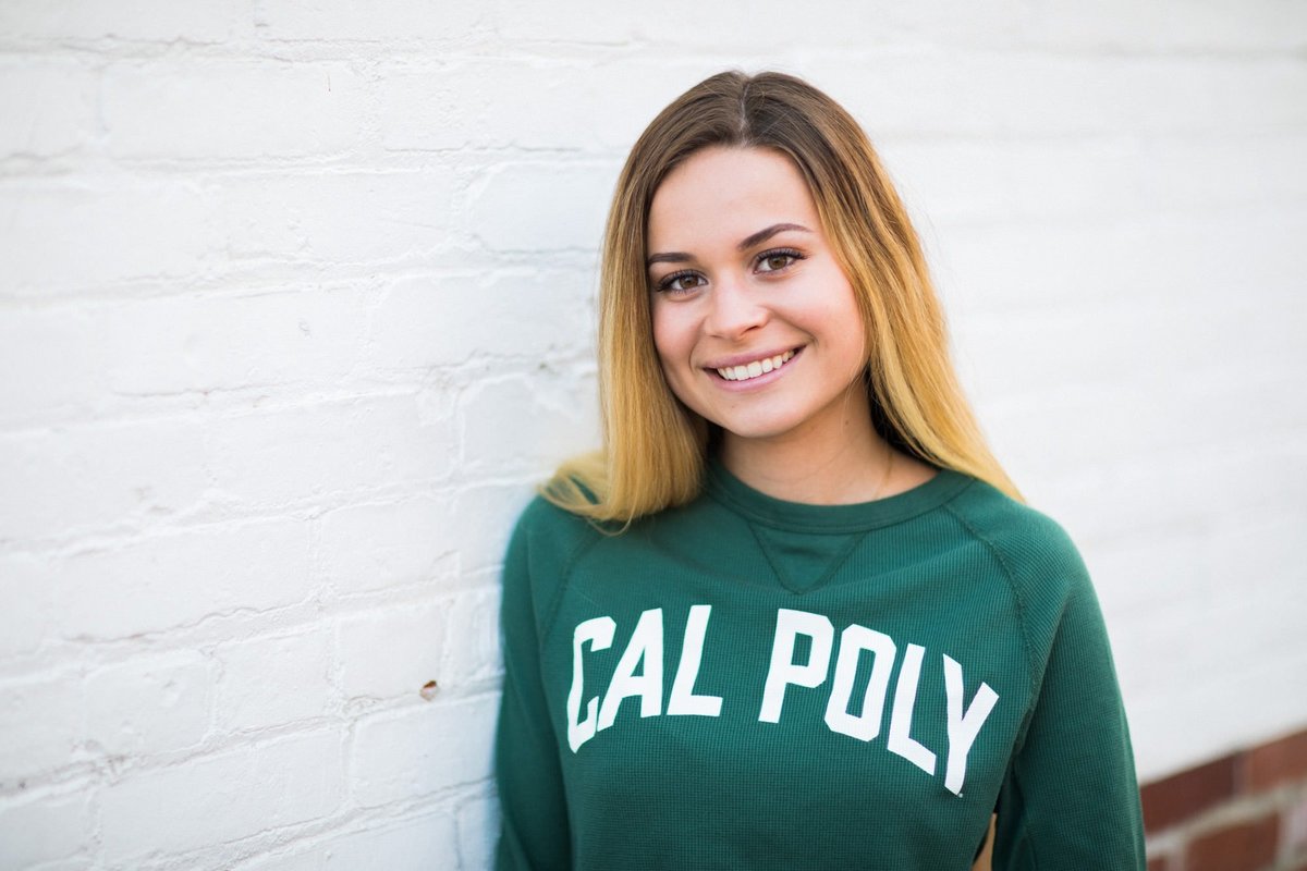 Young female college student smiles during her senior photo session