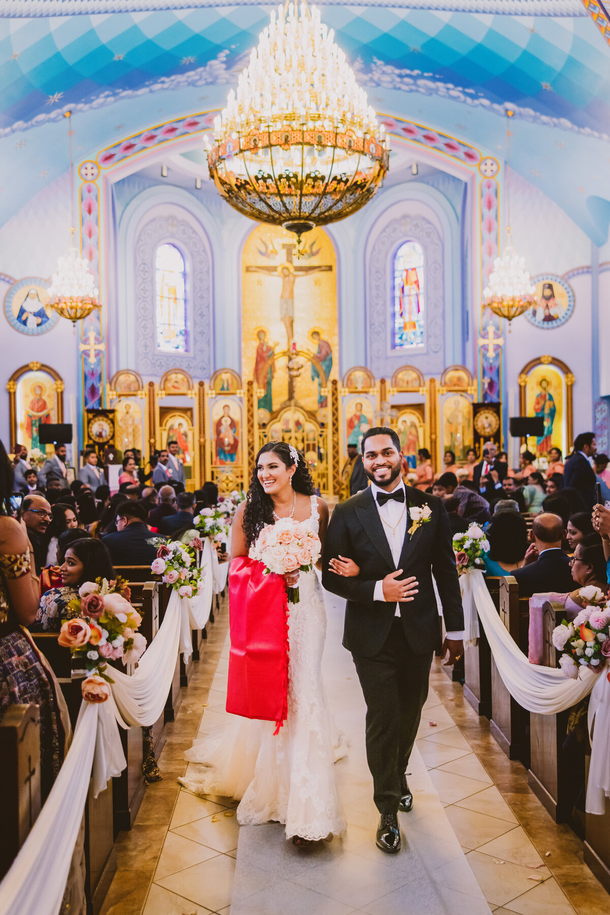 Indian christian malayali couple walking back down the aisle after the wedding ceremony