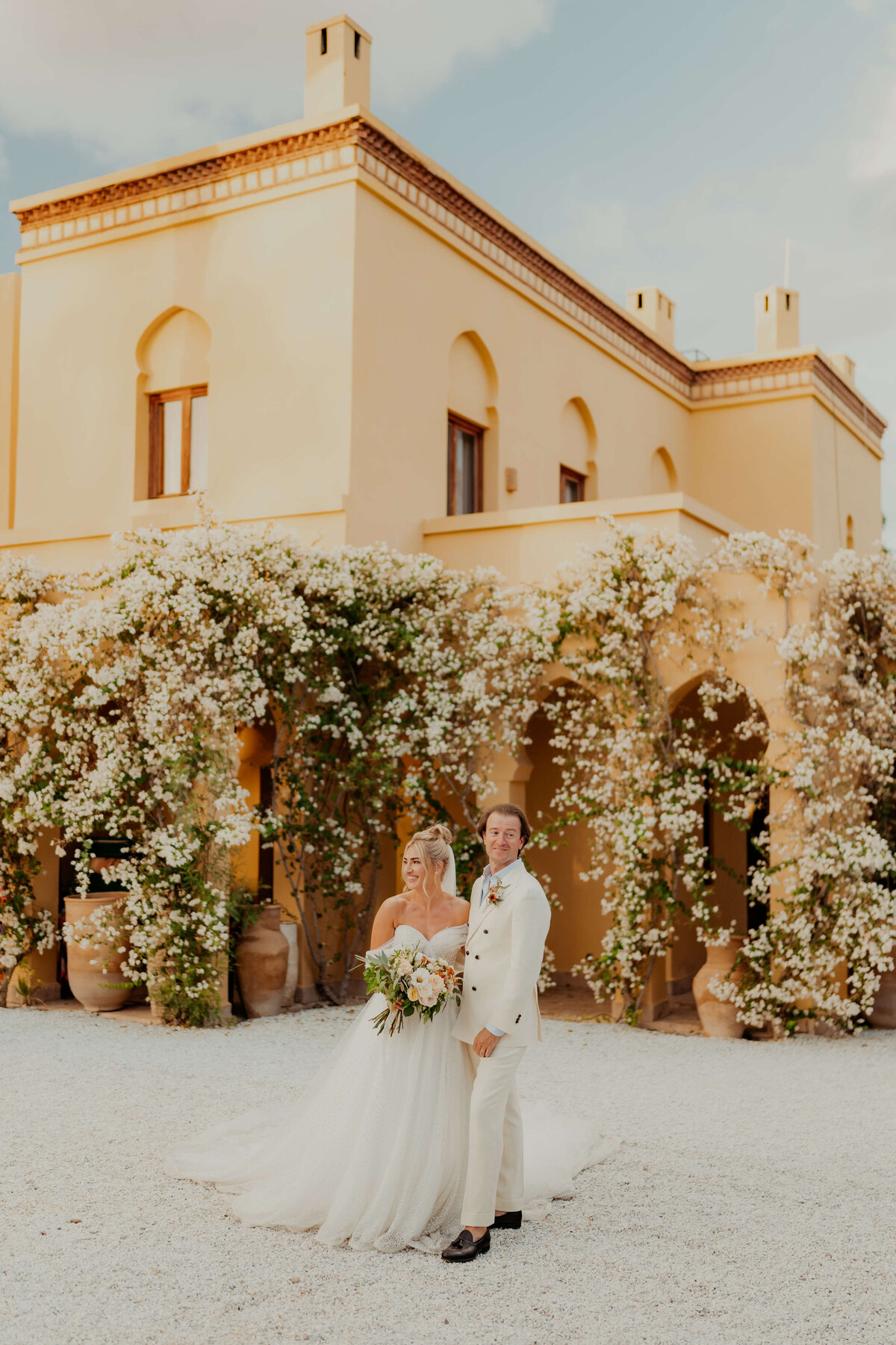 Bride and Groom Posing outside yellow building
