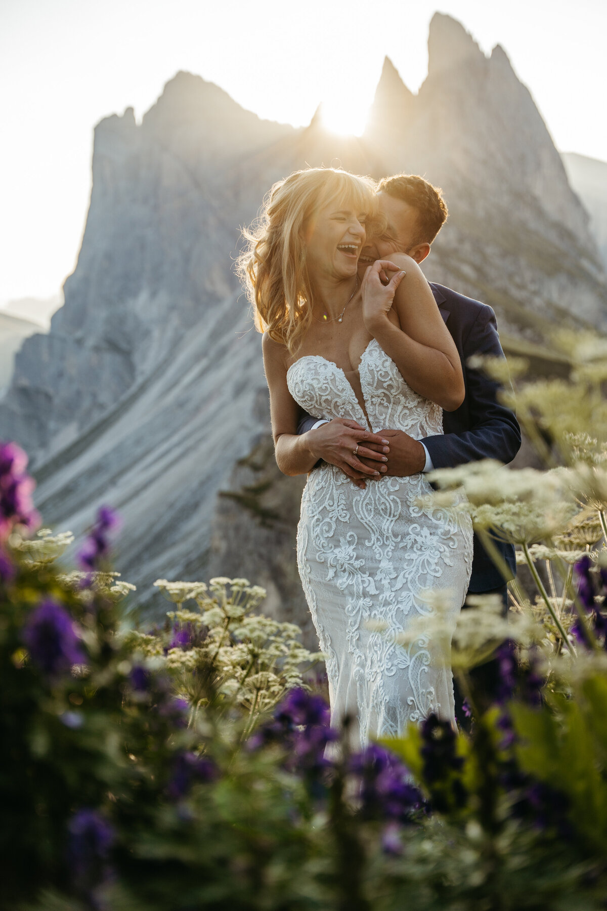 Bride and groom surrounded by purple wildflowers Dolomites