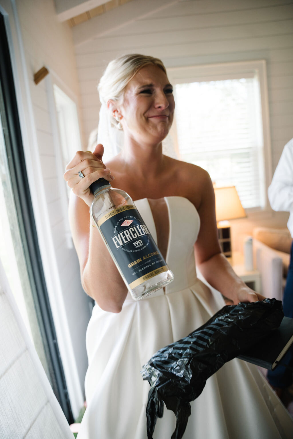 Bride cringing holding a bottle of everclear