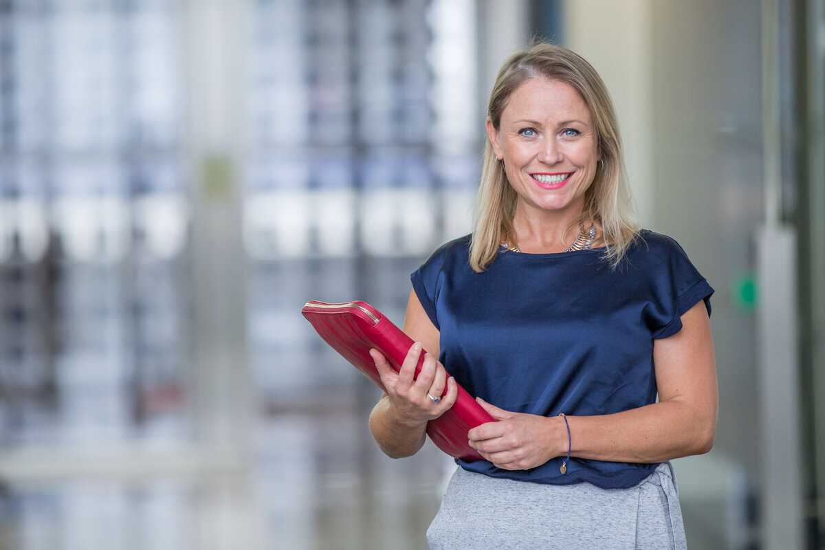 Professional photo of woman holding red folder