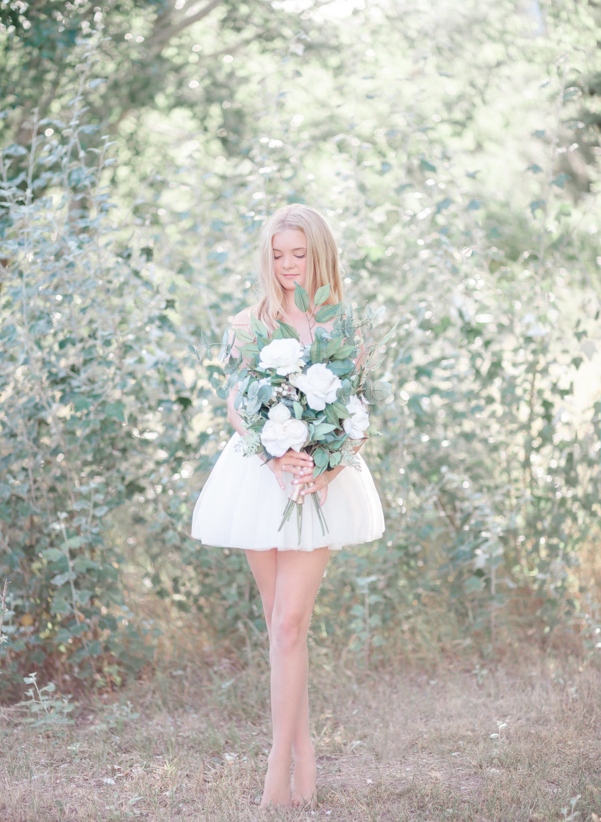 Beautiful young blond girl holding greenery bouquet bespoke child photography