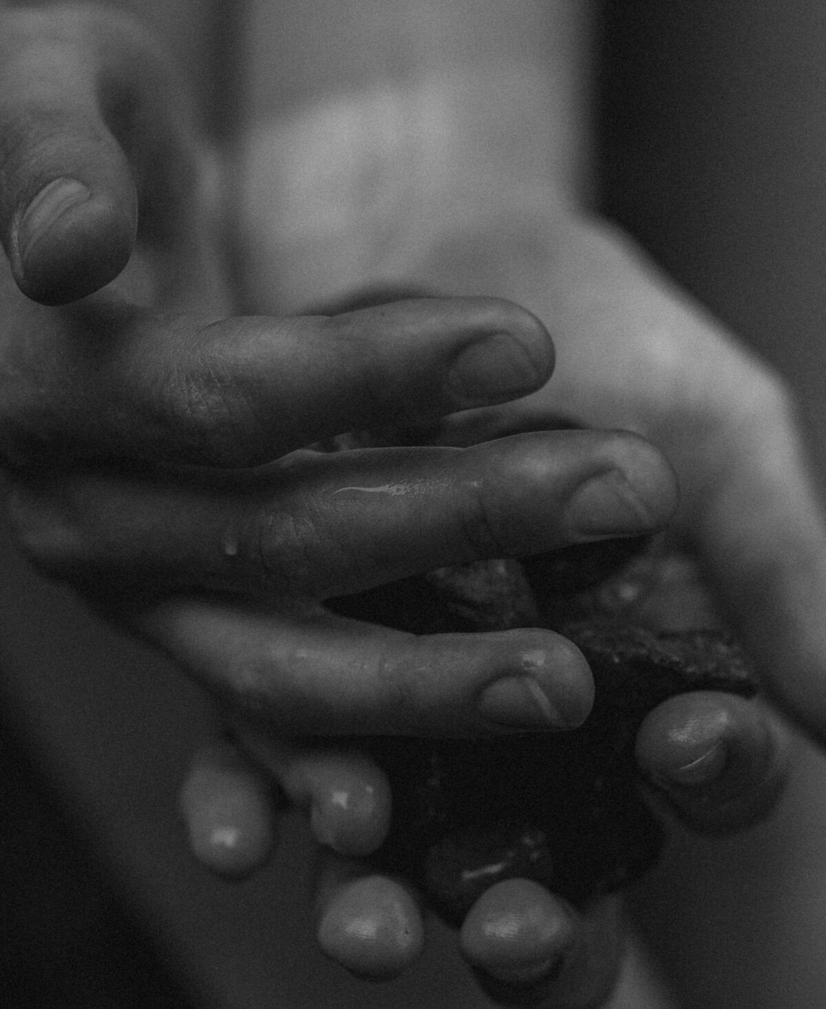 close up of female hands holding river rocks during an outdoor brand photoshoot in the high desert