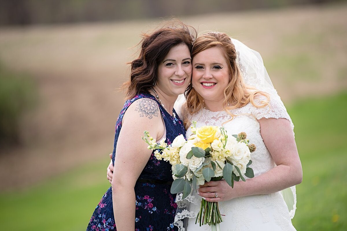 Bride posing with a friend after her outdoor wedding ceremony at White Barn in Prospect, PA