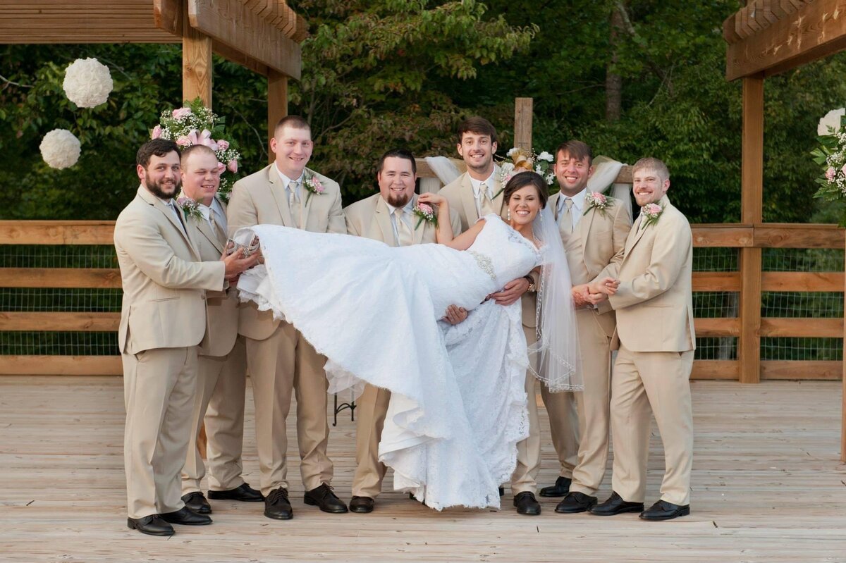 Groomsmen holding the bride after the ceremony