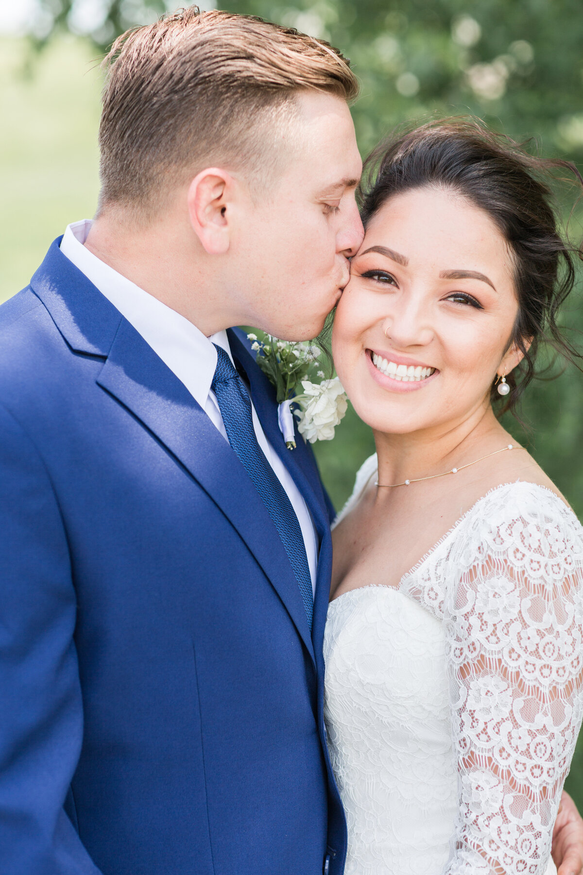 Man kissing wife's cheek on their wedding day