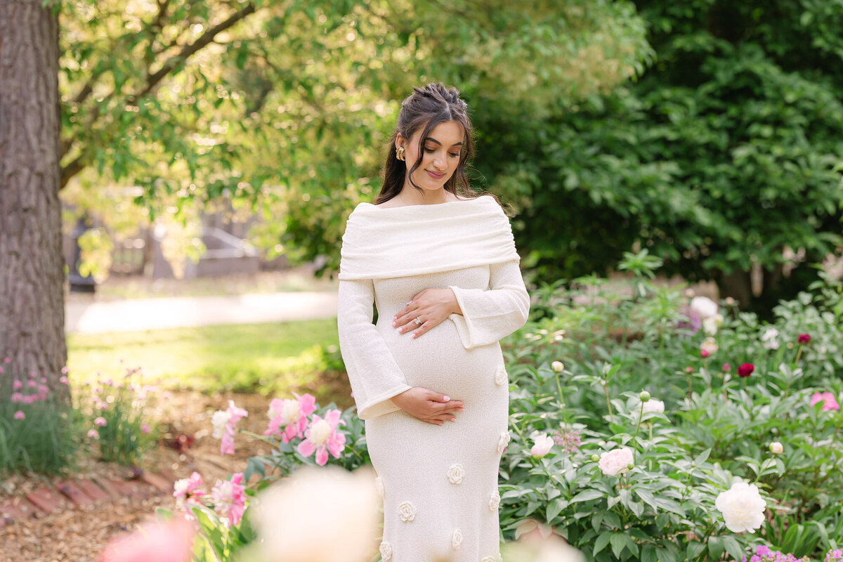 Portrait of a pregnant mom in a beautiful, bright garden in louisville kentucky holding her baby bump taken by missy marshall photography