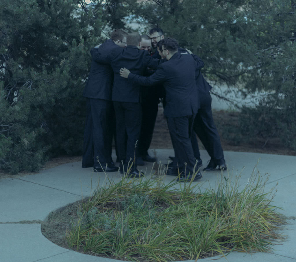 A wedding party huddled up together.