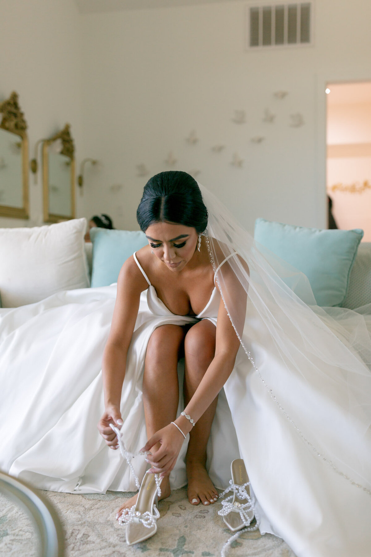 bride putting on bridal shoes