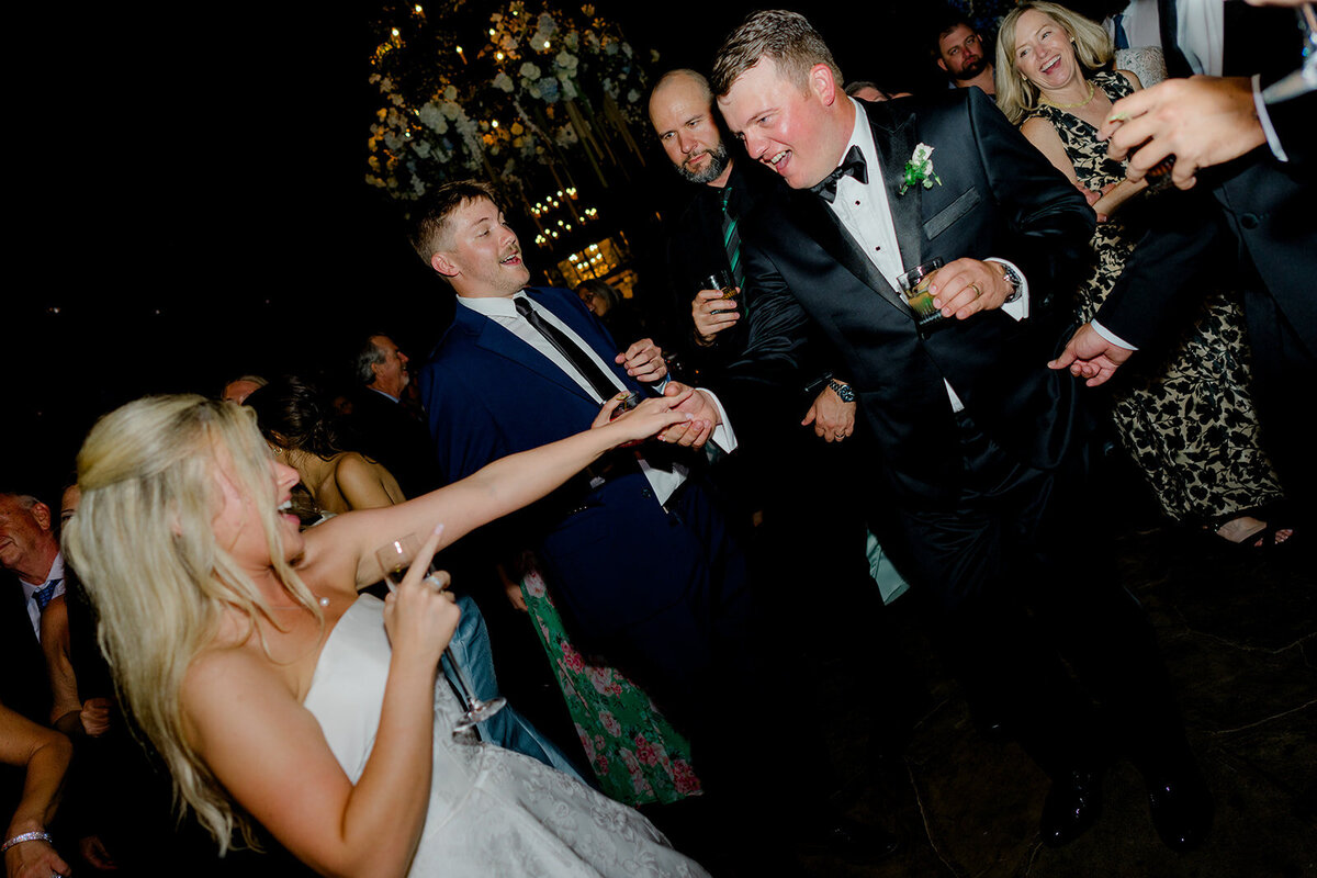 Candid dance floor moment of the bride and groom celebrating during a Highlands wedding reception.