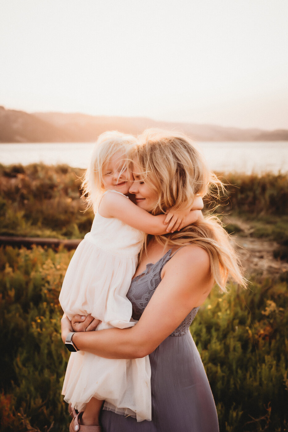 Mama holding daughter while they hug and close eyes