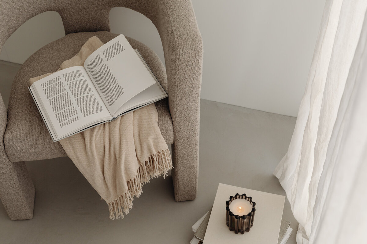 kaboompics_home-decorations-beige-armchair-candles-book-blanket-32098