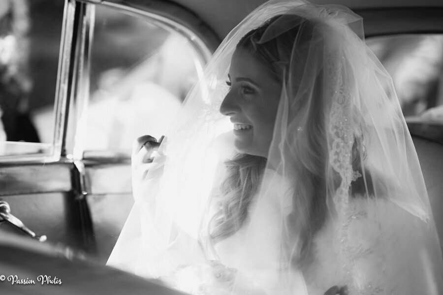 A black and white photo captures a bride sitting elegantly in a car, adding a timeless and classic touch to her bridal portrait. This image emphasizes the sophistication and elegance of the moment, showcasing our ability to create stunning, emotive portraits with a vintage feel.