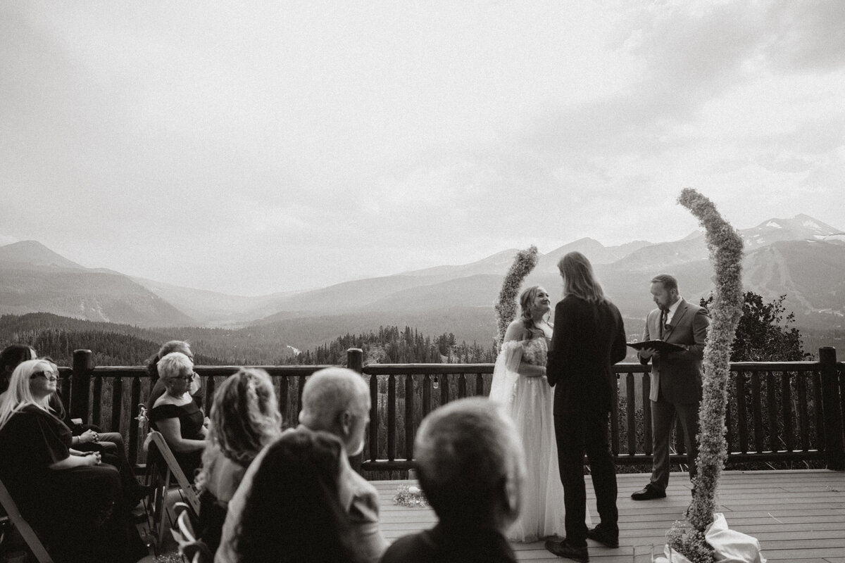 Mountain view wedding ceremony on deck of the Lodge at Breckenridge with guests and heartfelt vows.