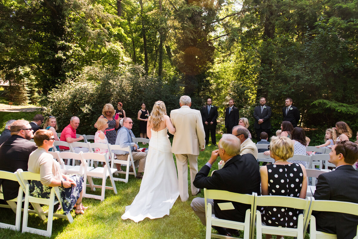 picture of the bride walking down the aisle with her dad at her Hyeholde wedding ceremony