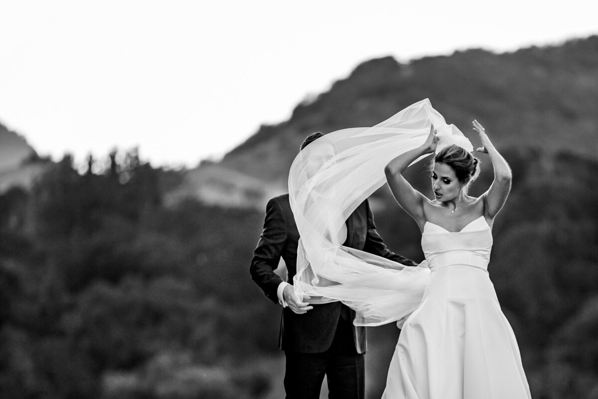 Black and white photo of a bride adjusts her head gown covering on her Vera Wang wedding dress in Los Angeles, photo by Tanya Parada 