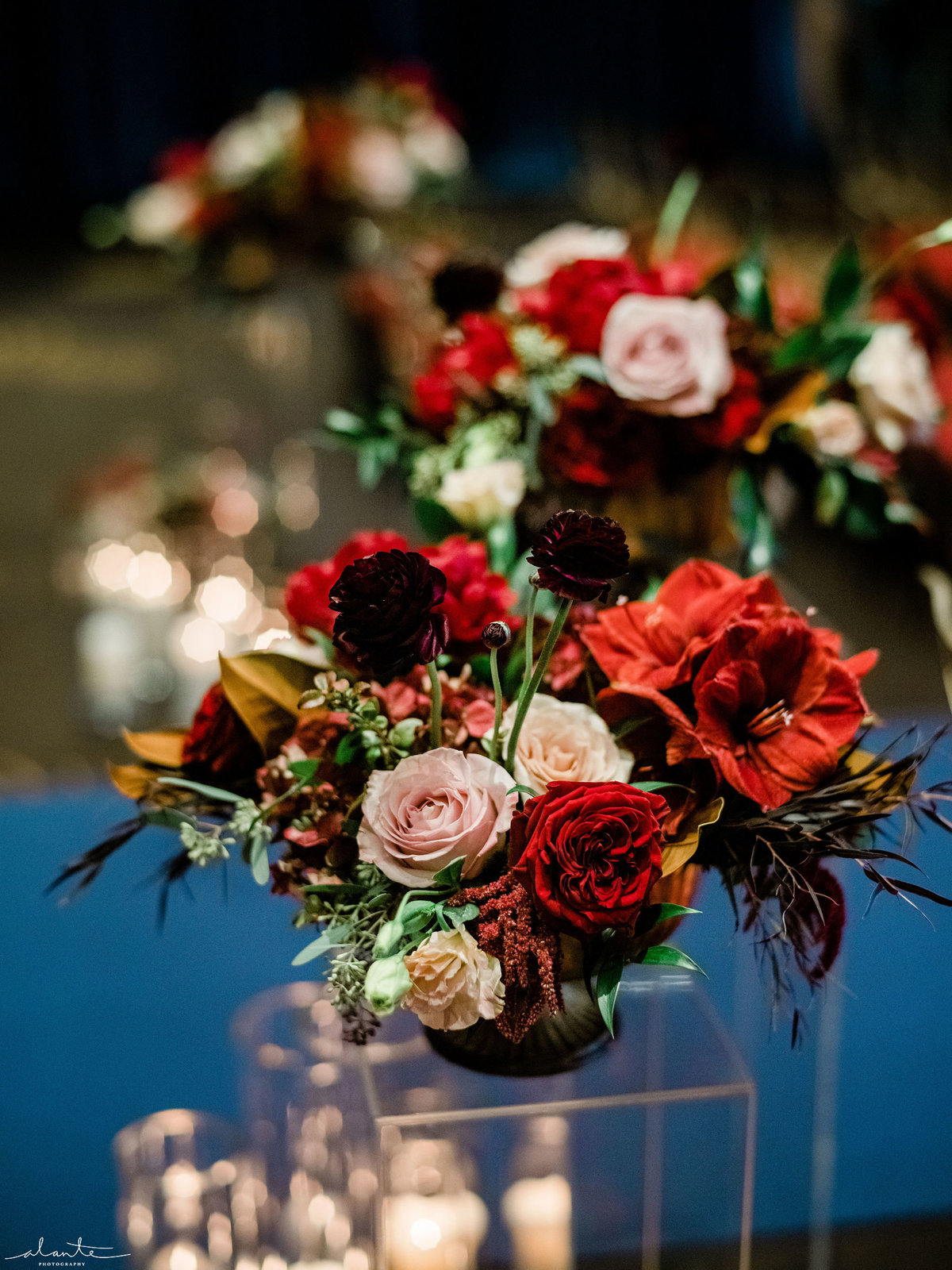 Ceremony aisle flowers in deep red on clear lucite pedestals